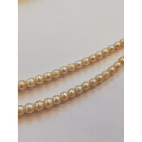 129 - A cultured pearl choker with diamond set clasp, comprising two rows of off-round cultured pearls, me... 