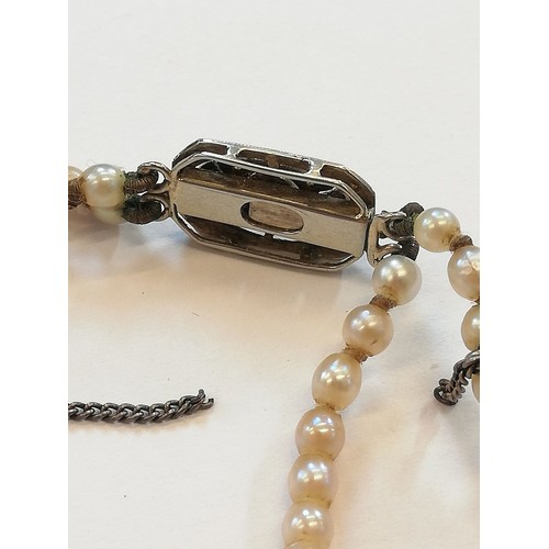 129 - A cultured pearl choker with diamond set clasp, comprising two rows of off-round cultured pearls, me... 