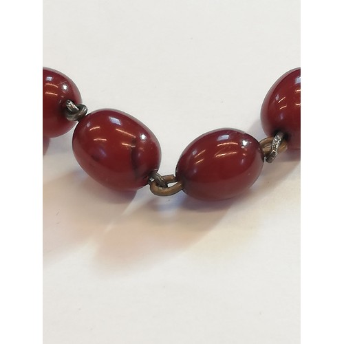 150 - A cherry amber bead necklace, comprising thirty-four polished oval cherry amber beads, measuring bet... 