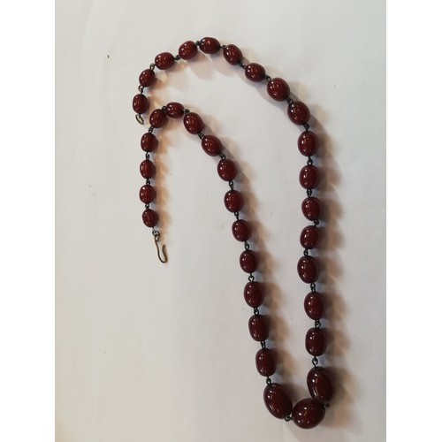 150 - A cherry amber bead necklace, comprising thirty-four polished oval cherry amber beads, measuring bet... 