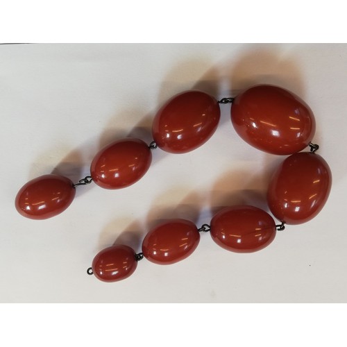 150 - A cherry amber bead necklace, comprising thirty-four polished oval cherry amber beads, measuring bet... 