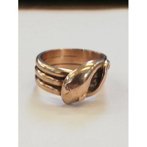 138 - A 9ct gold snake ring, the snakes head modelled with diamond shaped eyes and coiled tail to a reeded... 