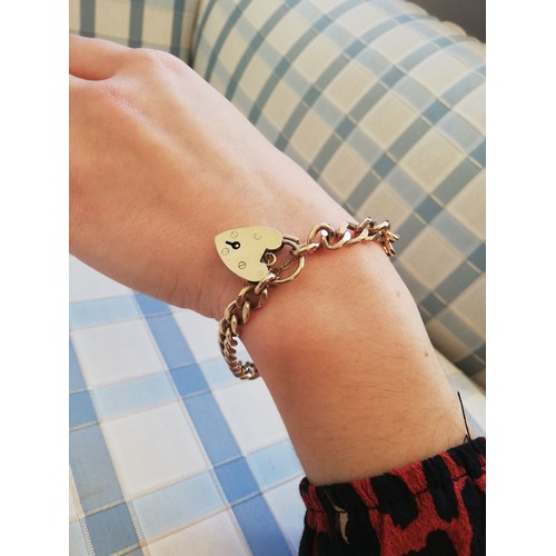 142 - A 9ct gold curb link bracelet, 20cm long, suspending a 9ct gold padlock fastening, marks for Cropp &... 