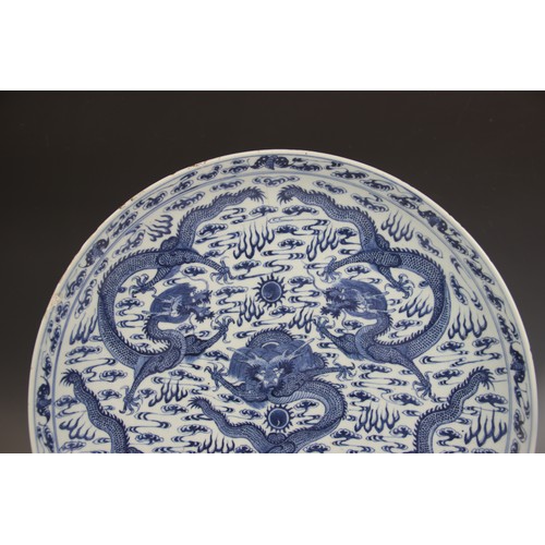 408 - A large Chinese porcelain blue and white 'Dragon' charger, Kangxi mark, the shallow circular charger... 