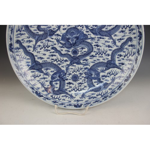 408 - A large Chinese porcelain blue and white 'Dragon' charger, Kangxi mark, the shallow circular charger... 