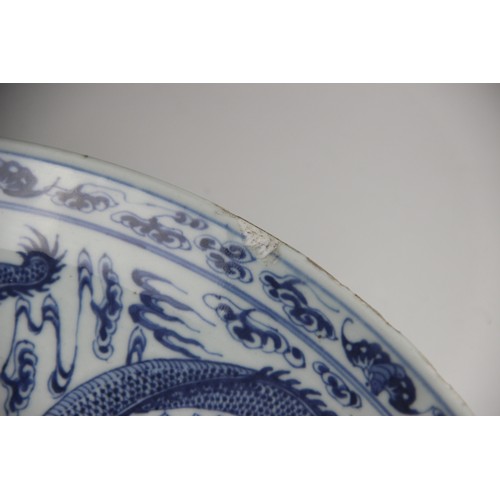 408 - A large Chinese porcelain blue and white 'Dragon' charger, Kangxi mark, the shallow circular charger... 