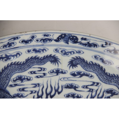 408 - A large Chinese porcelain blue and white 'Dragon' charger, Kangxi mark, the shallow circular charger... 