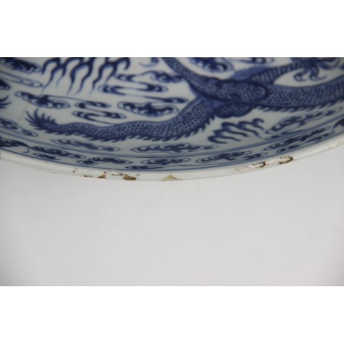 408 - A large Chinese porcelain blue and white 'Dragon' charger, Kangxi mark, the shallow circular charger... 