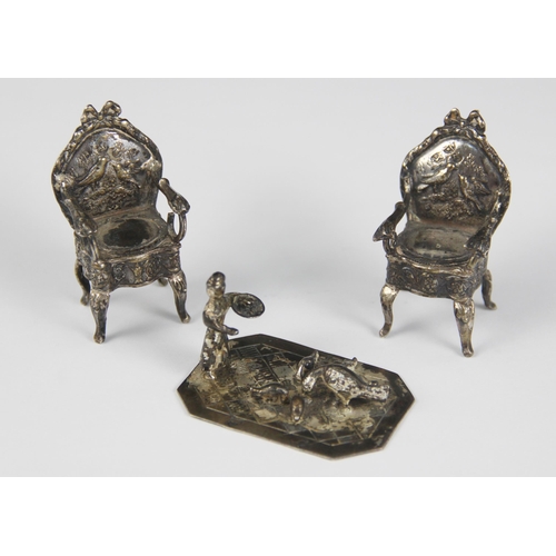 11 - A pair of silver coloured miniature fauteuil chairs, the padded seats upon cabriole legs and scrolli... 