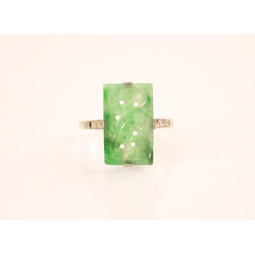 156 - An Art Deco jade and diamond ring, the central rectangular carved and pierced jade panel measuring 1... 