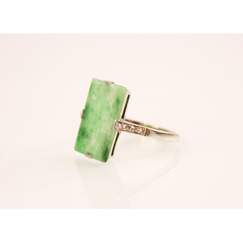 156 - An Art Deco jade and diamond ring, the central rectangular carved and pierced jade panel measuring 1... 