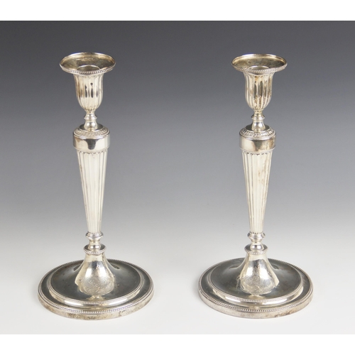 71 - A pair of George III Neo-classical silver candlesticks, probably John Schofield, London 1780, the ta... 