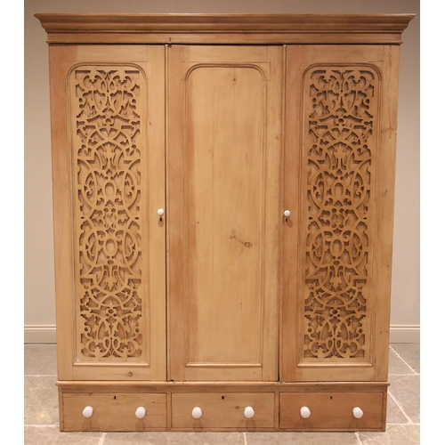 749 - A Victorian pine triple wardrobe, the moulded cornice above three doors, the plain panelled centre d... 