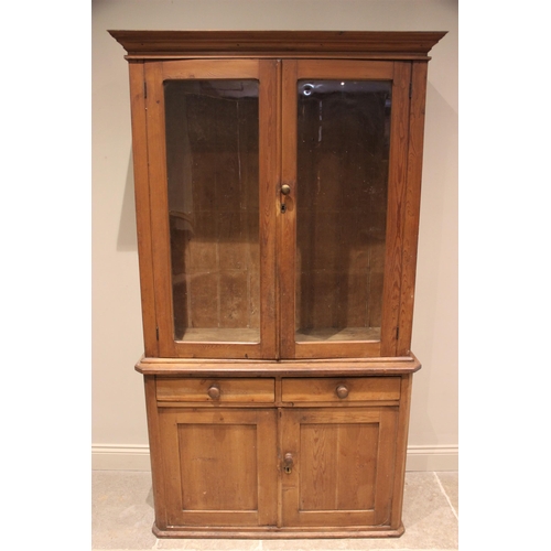 765 - A Victorian glazed pine housekeepers cupboard, the moulded cornice above a pair of glazed cupboard d... 