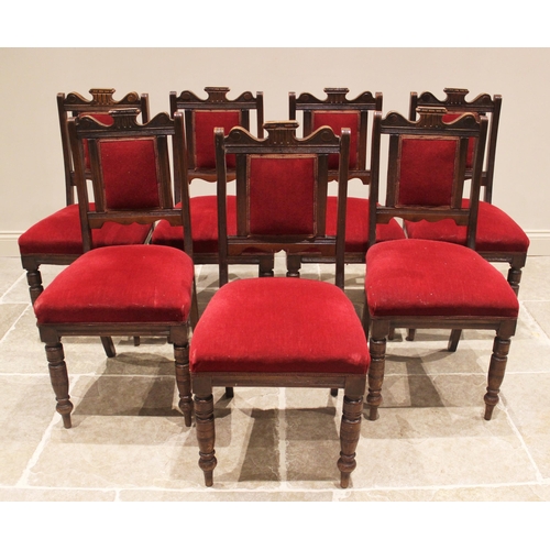 790 - A set of seven Victorian oak and red velour dining chairs, each with a shaped top rail above a padde... 