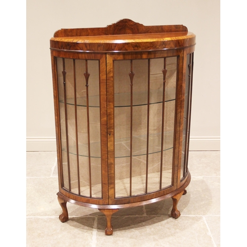 801 - A 1930's figured walnut bowfront display cabinet, with a rear gallery over a single convex door open... 