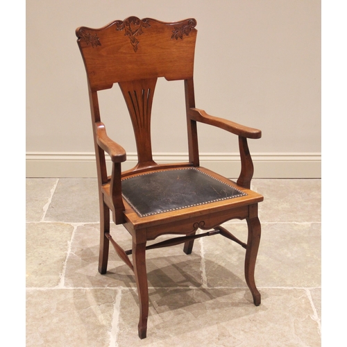 813 - An American type walnut elbow chair, early 20th century, the rail back with incised foliate detail a... 