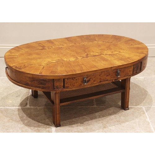 817 - A contemporary oak and pollard oak coffee table, the oval top with a central pollard oak panel enclo... 