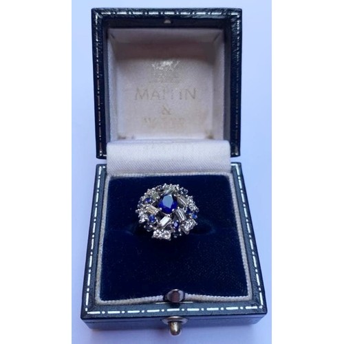 149 - A sapphire and diamond cluster ring, the central oval mixed cut sapphire measuring 6mm x 5mm, within... 