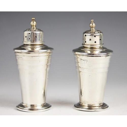 70 - A pair of Indian Art Deco silver pepperettes, Warner Bros Delhi, each of tapered cylindrical form of... 