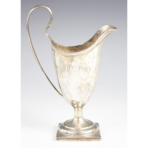 90 - A George III silver helmet-shaped milk jug, Thomas Wallis I, London 1784, plain polished with beaded... 