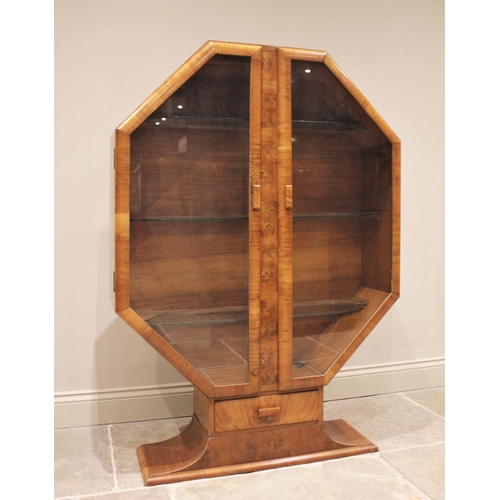 799 - A 1930's Art Deco octagonal walnut display cabinet, the pair of glazed doors opening to two glass sh... 