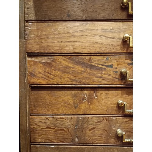 811 - An early 20th oak map chest, the rectangular moulded top above fifteen drawers applied with angular ... 