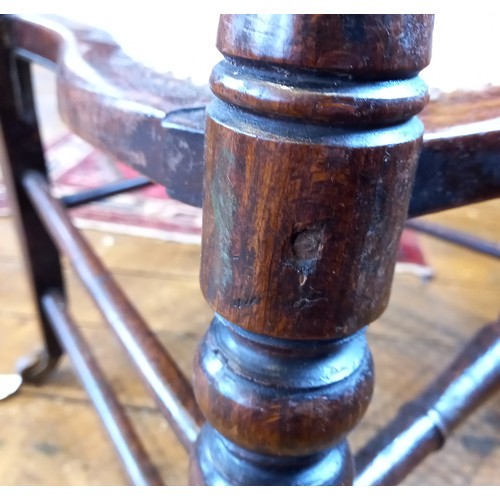 793 - A 19th century beech and fruit wood rocking chair, the spindled back above a rattan seat, raised upo... 