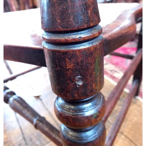 793 - A 19th century beech and fruit wood rocking chair, the spindled back above a rattan seat, raised upo... 