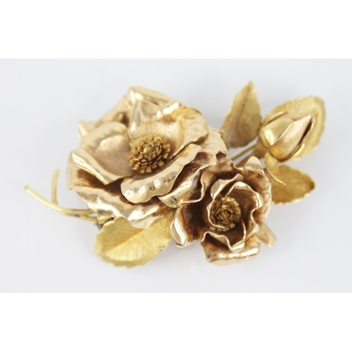 116 - An 18ct gold floral spray brooch, designed as two rose gold floral heads and a bud, set to a brushed... 