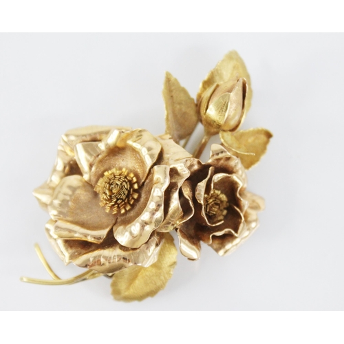 116 - An 18ct gold floral spray brooch, designed as two rose gold floral heads and a bud, set to a brushed... 