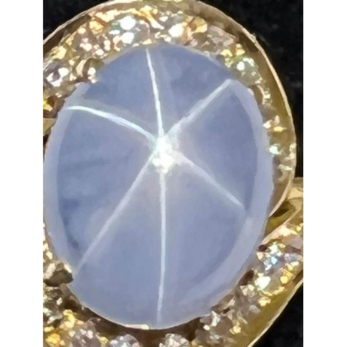 123 - A mid-20th century star sapphire and diamond 18ct gold ring, the central oval cabochon blue sapphire... 