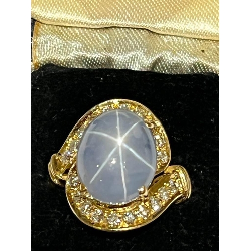 123 - A mid-20th century star sapphire and diamond 18ct gold ring, the central oval cabochon blue sapphire... 