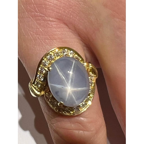 123 - A mid-20th century star sapphire and diamond 18ct gold ring, the central oval cabochon blue sapphire... 