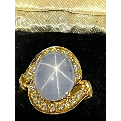 123 - A mid-20th century star sapphire and diamond 18ct gold ring, the central oval cabochon blue sapphire... 