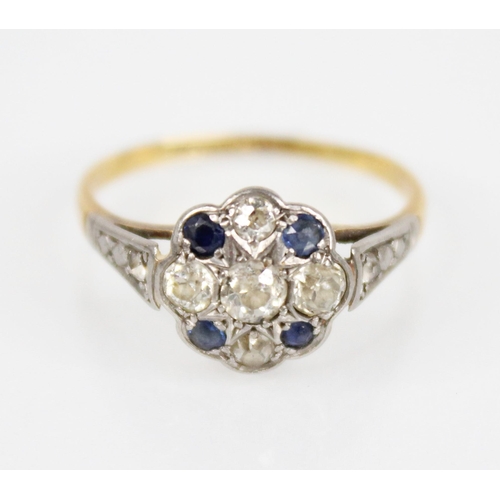 128 - An early 20th century sapphire and diamond floral cluster ring, the central floral head set with fiv... 