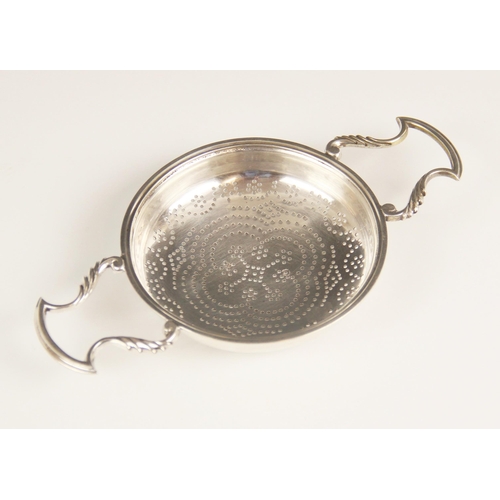 13 - A George II silver lemon strainer, London 1748 (maker's mark worn), the circular bowl with pierced d... 