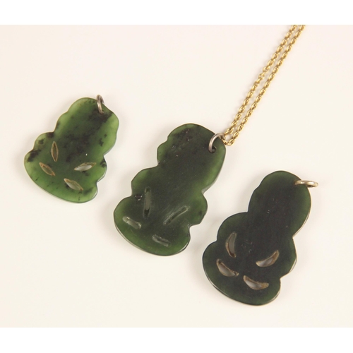 155 - Three New Zealand jade Tiki pendants, one with attached yellow metal chain, largest 4cm, smallest 3c... 