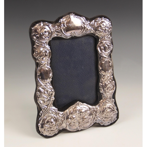 22 - A silver mounted photograph frame, John Bull Ltd, London 1981, of rectangular scalloped form, the sc... 