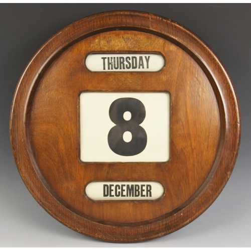 572 - A circular mahogany perpetual wall calendar, mid 20th century, the front with three glazed apertures... 