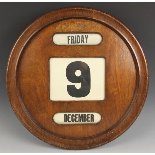 572 - A circular mahogany perpetual wall calendar, mid 20th century, the front with three glazed apertures... 