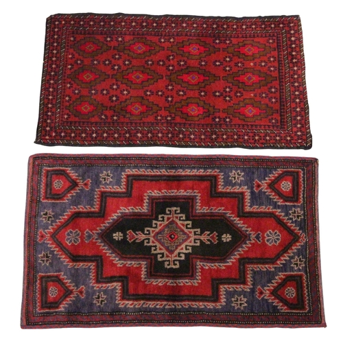 614 - A Caucasian wool rug, in red and blue colourways, with central graduated geometric medallions, enclo... 