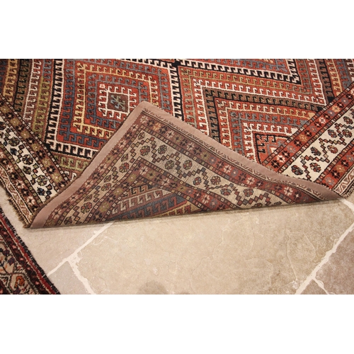 616 - A Caucasian hand knotted wool carpet, in brown, blue, black and white colourways, the central field ... 