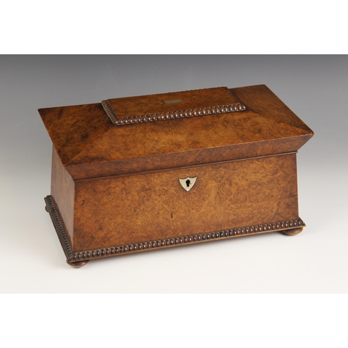 665 - A burr walnut and rosewood sarcophagus shaped tea caddy, early 19th century, the hinged cover inlaid... 