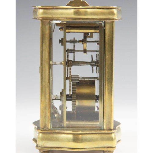 679 - A late 19th century lacquered brass carriage timepiece, the serpentine case with a swing handle abov... 