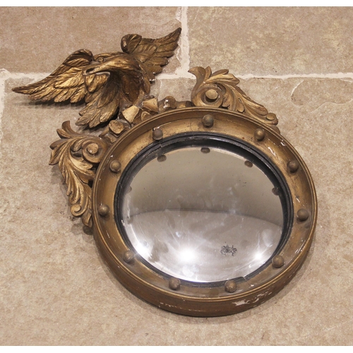 695 - A Regency giltwood and gesso convex wall mirror, of diminutive proportions, the eagle crest extendin... 