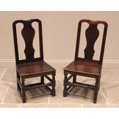 708 - A near pair of early 18th century oak chairs, each with a vase shaped splat over a board seat, raise... 