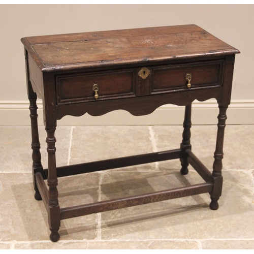 709 - An 18th century oak side table, the moulded plank top above a single frieze drawer, moulded as a pai... 