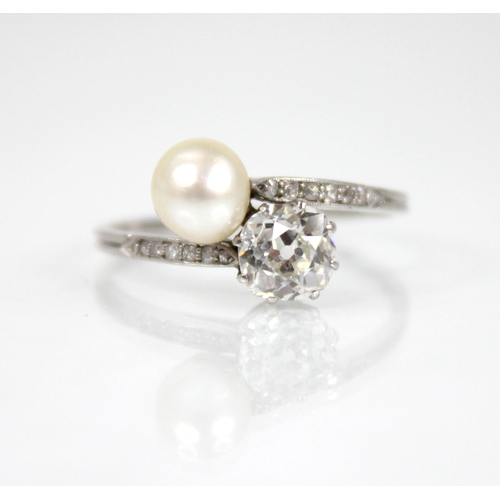 72 - An early 20th century diamond and pearl ‘moi et toi’ ring, comprising an old cut diamond measuring 5... 