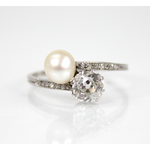 72 - An early 20th century diamond and pearl ‘moi et toi’ ring, comprising an old cut diamond measuring 5... 